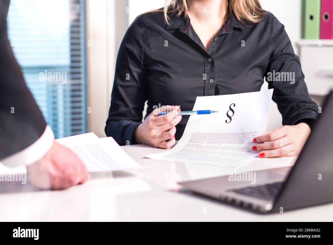 Female lawyer and attorney pointing a legal document in meeting with colleague. Team and company working. Teamwork in law firm. Stock Photo