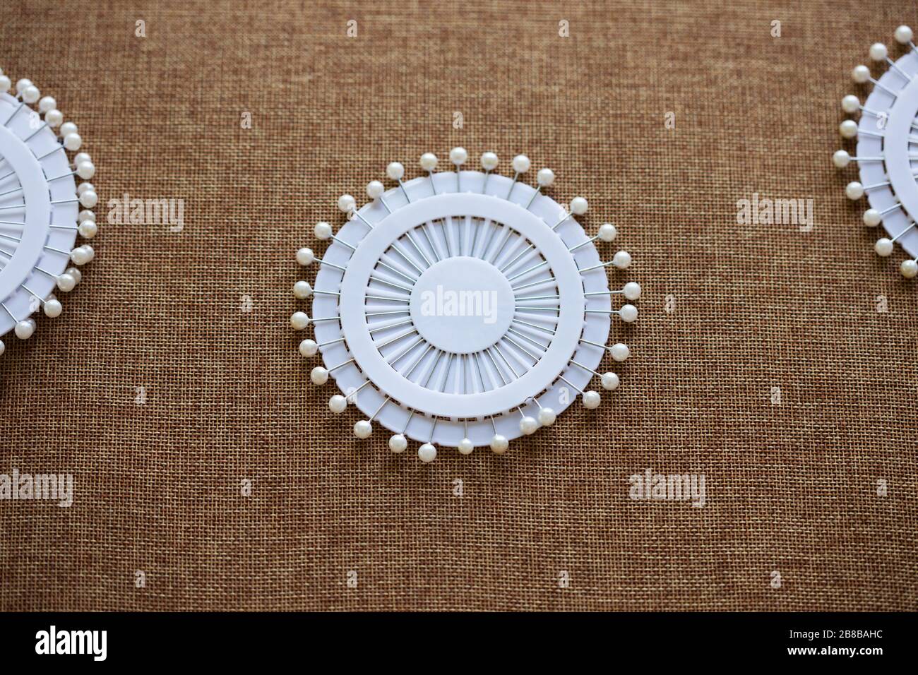 Pin set for sewing on dark canvas texture background. Tools and accessories florists snd sewing. Stock Photo