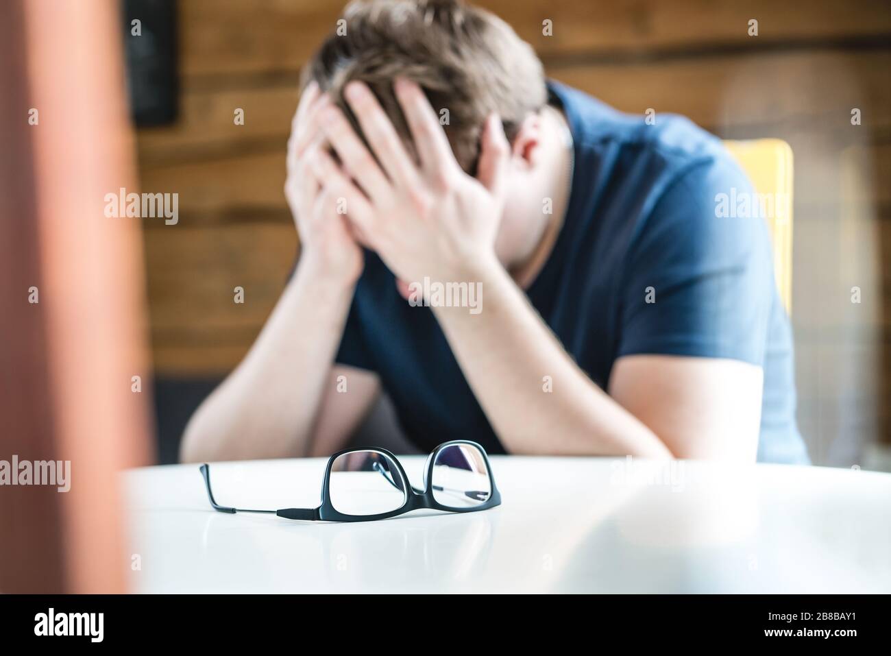 Discrimination, loneliness, mental health or depression concept. Sad upset man holding head or eyes. Suffering from headache, insomnia or problems. Stock Photo