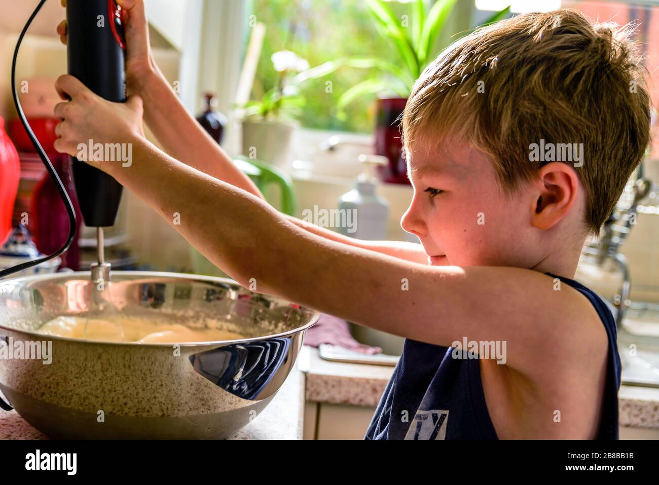 child boy making pancake mix with blender in kitchen Stock Photo Alamy