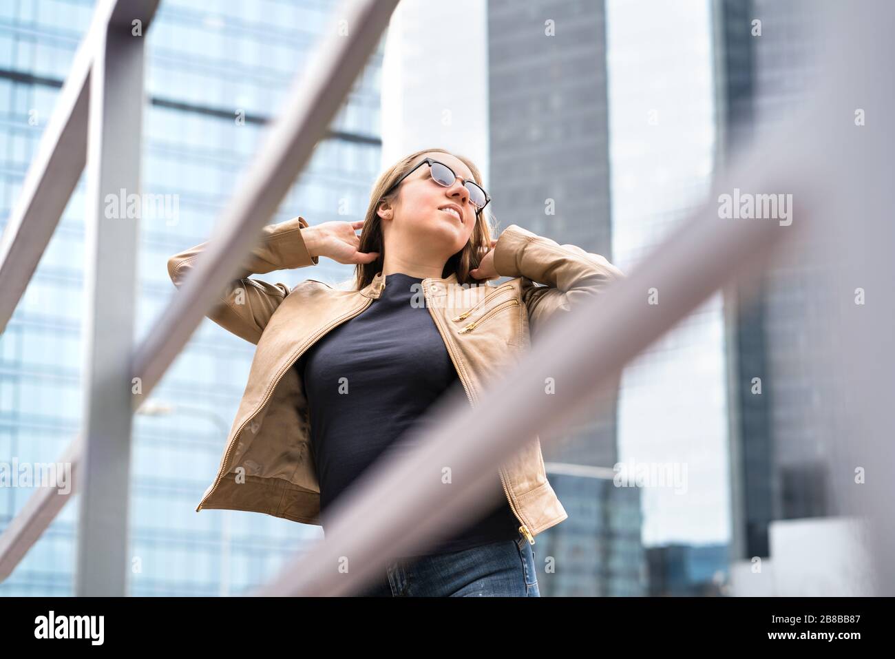 Independent, confident and powerful woman in city. Happy healthy model with sunglasses and good fashion style. Stock Photo