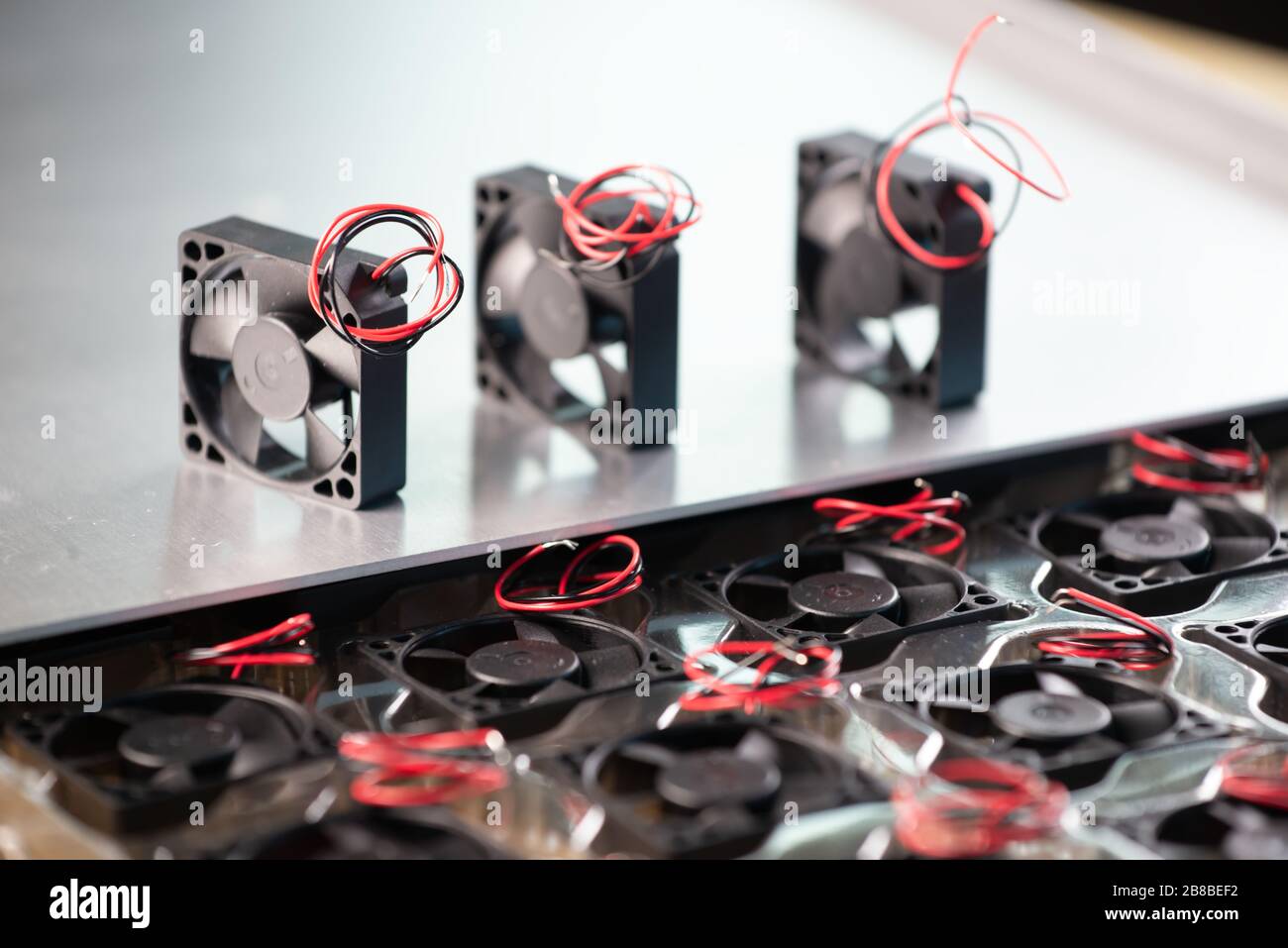 Closeup of three small computer coolers with wires lying on a table on