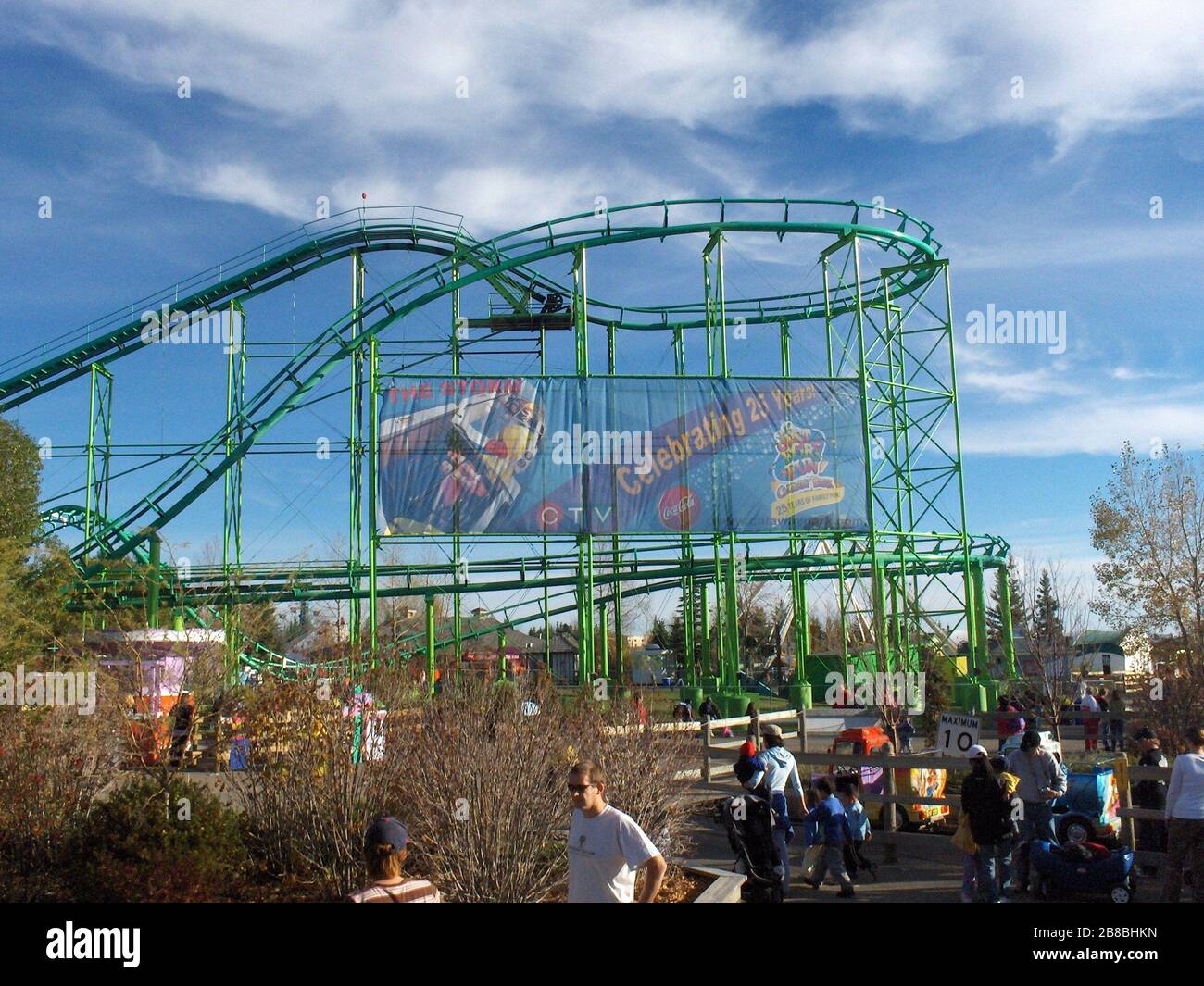 'English: Calaway Park (Calgary, Canada) - A banner of Calaway celebrating it's 25th Anniversary with the new ride Storm, posted on Vortex's (the roller coaster) side railings. Other rides are shown, including Swirly Twirl (left), Super Trucks (right) and Ocean Motion in the background. The Calaway Cafe is shown behind vortex (gray-roofed building), and the Guest Services booth to the right of it (smaller white building).; 9 October 2006; Own work (Original text:  Picture shot by employee (ride operator) of Calaway); Jonathan Verge; ' Stock Photo