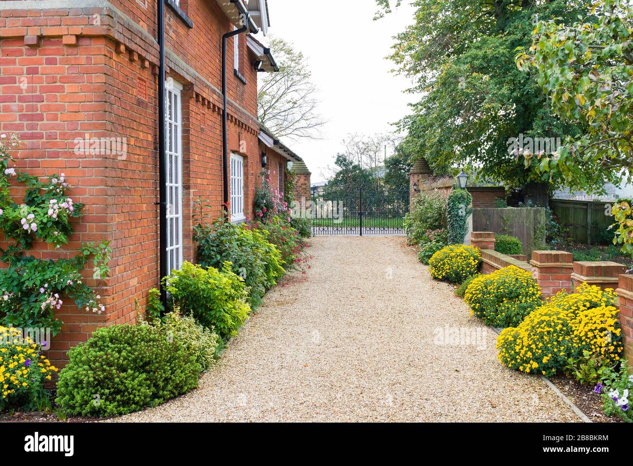 Large English country mansion house from Victorian period in the UK, with wrought iron gates and gravel drive. Stock Photo