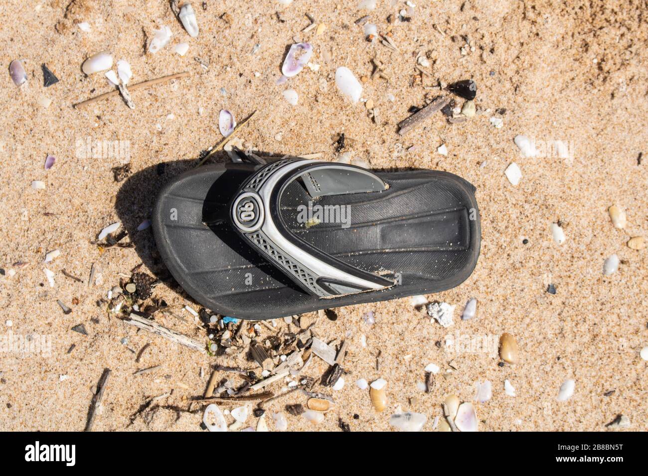 Beirut, Lebanon. 21 March 2020. A sandal discarded on a polluted beach ...