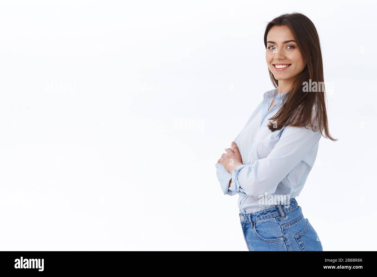 Confident successful businesswoman standing like professional, smiling satisfied, stand in profile near white copy space and turn face to came with Stock Photo