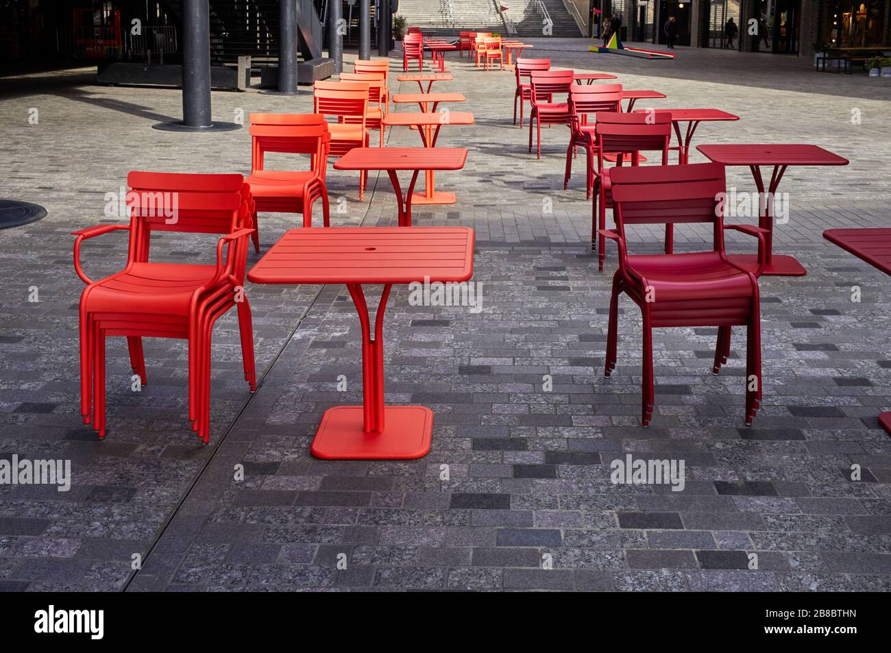 Two tones of red outdoor tables at Coal Drops Yard retail area in Kings Cross, London Stock Photo