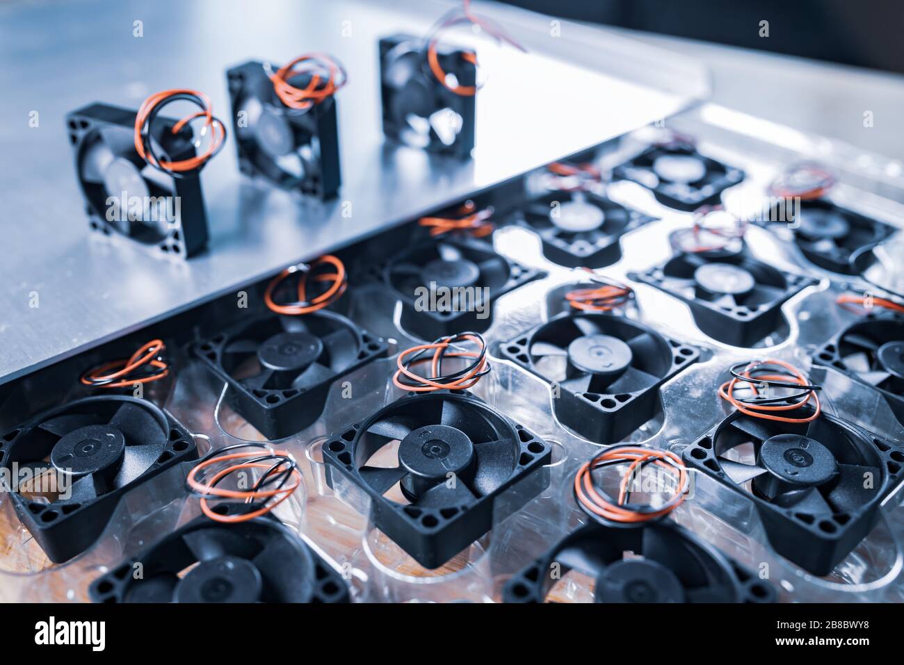 Closeup of three small computer coolers with wires lying on a table on