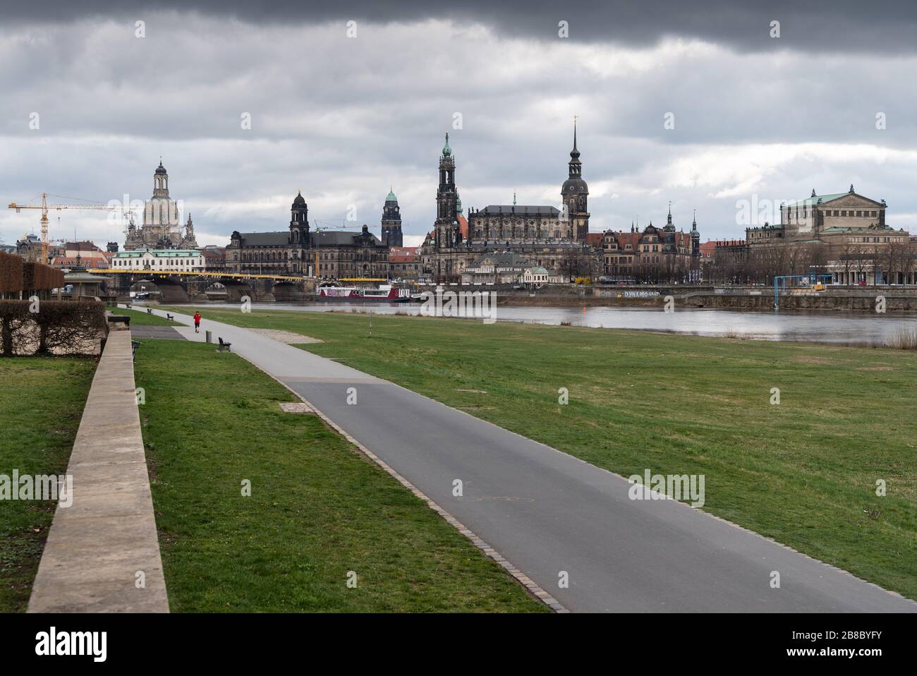 Dresden, Germany. 21st Mar, 2020. The Elbe Cycle Route is almost deserted  against the historical backdrop of the Old Town with the Frauenkirche  (l-r), the Ständehaus, the Rauthaus, the Hofkirche, the Hausmannsturm,