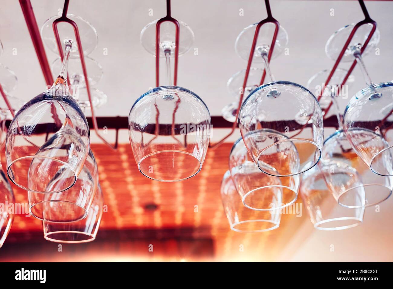 Wine glasses hanging on a bar rack Stock Photo