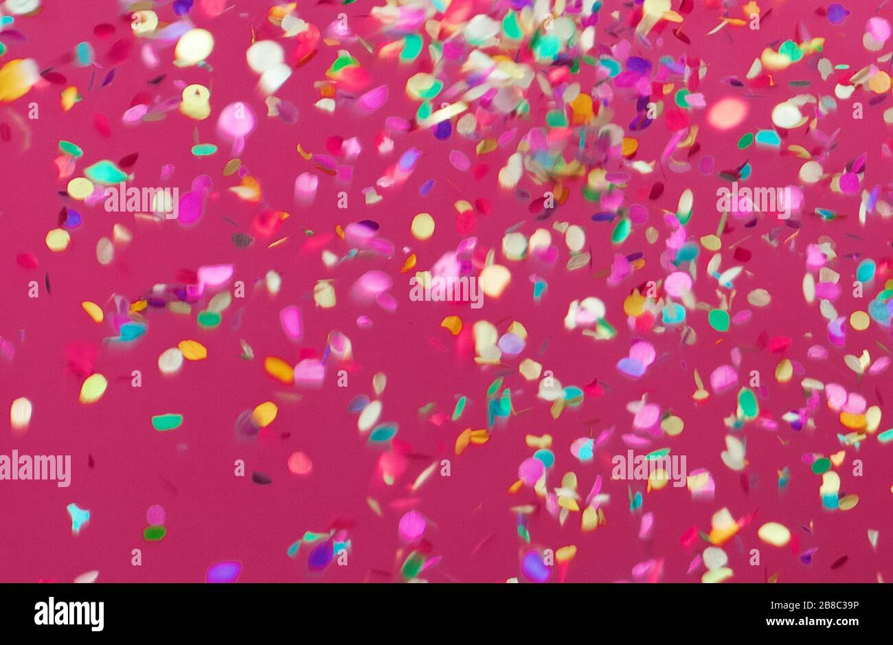 Colorful confetti falling on pink background Stock Photo Alamy