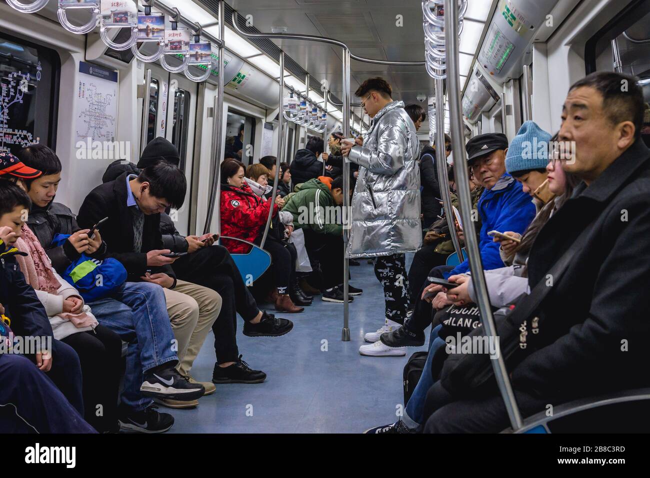 Students play online games inside a subway train in Beijing