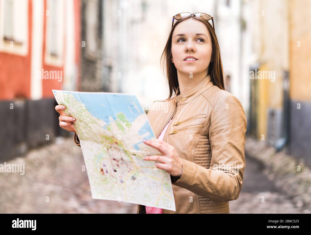 Female traveler with map. Woman traveling. Determined and confident person exploring the world. Freedom and wanderlust. Urban stylish lifestyle. Stock Photo