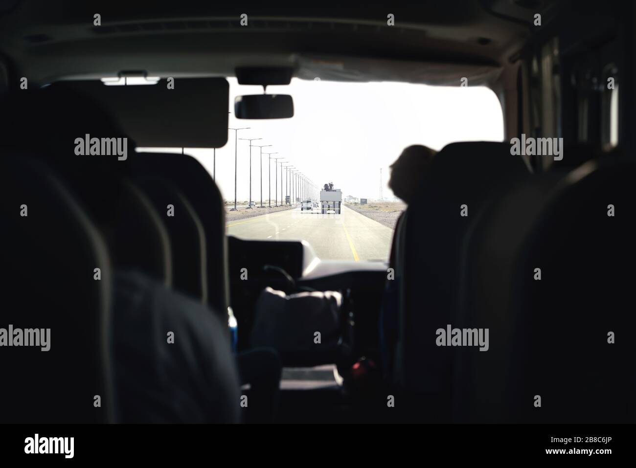 Bus on highway. Coach, shuttle or minivan. Airport transfer with taxi van. Passenger interior view from back seat. Tourist tour excursion. Stock Photo