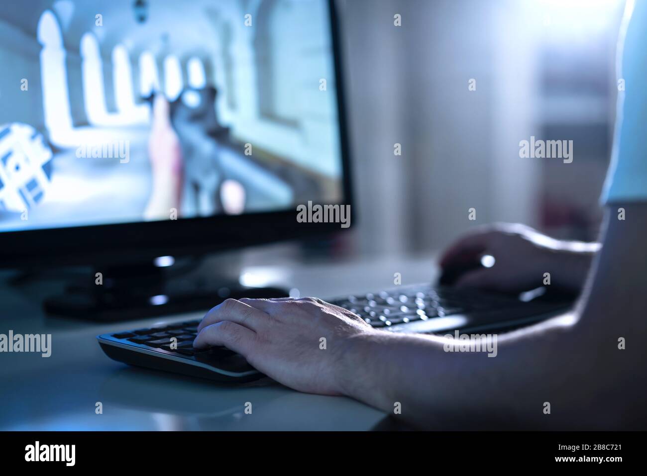 Video gamer with fps team strategy game. E sports and gaming concept. Professional competitive event. Man playing video game with desktop pc computer. Stock Photo