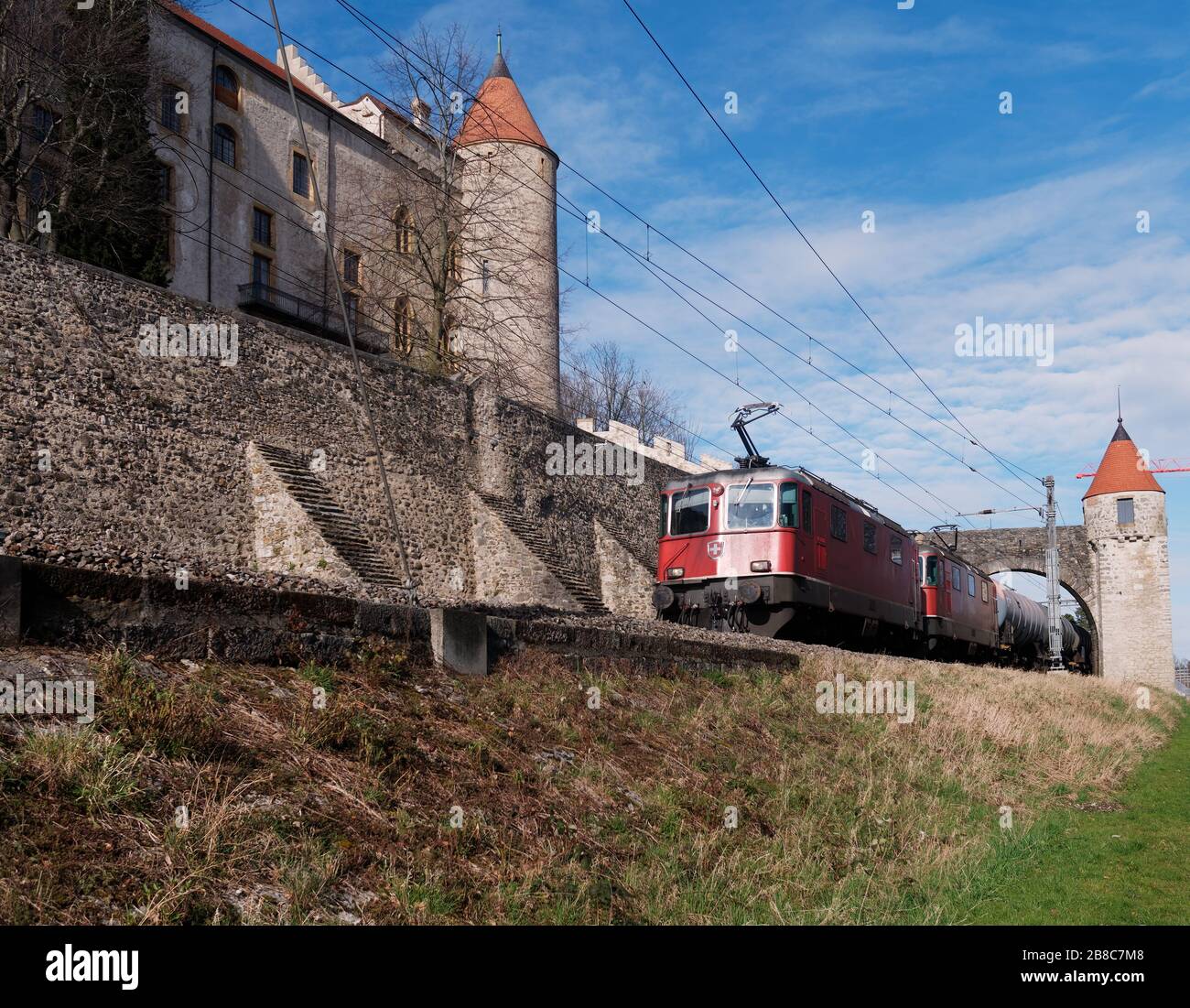 Freight train going through the medieval gate of the Grandson Castle, Canton of Vaud, Switzerland. Stock Photo