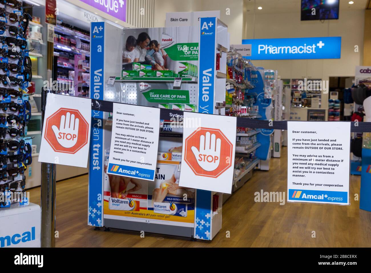 Coronavirus warning signs and safety barriers at an Amcal pharmacy at the international