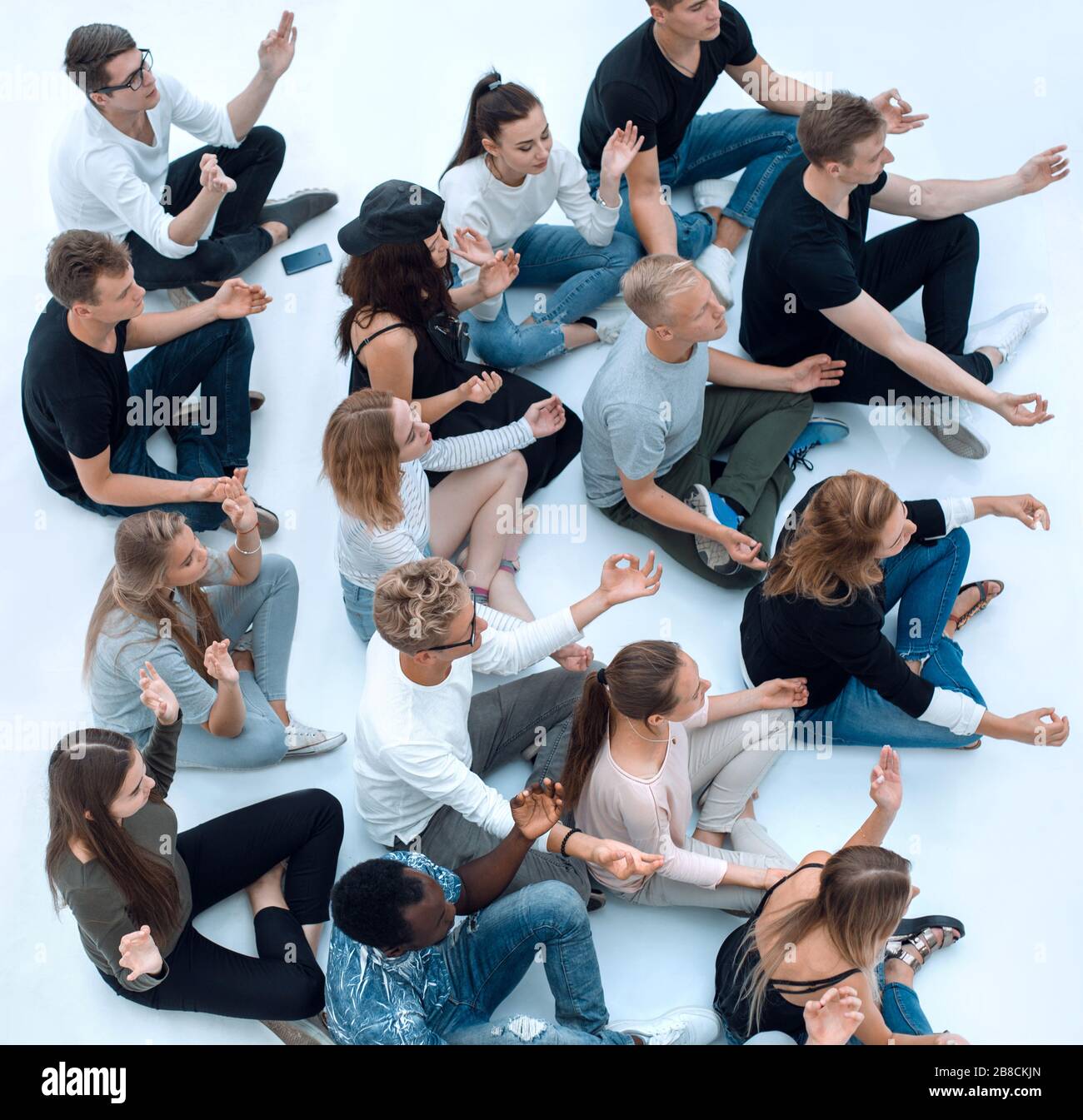 group of diverse young people meditate sitting on the floor Stock Photo ...