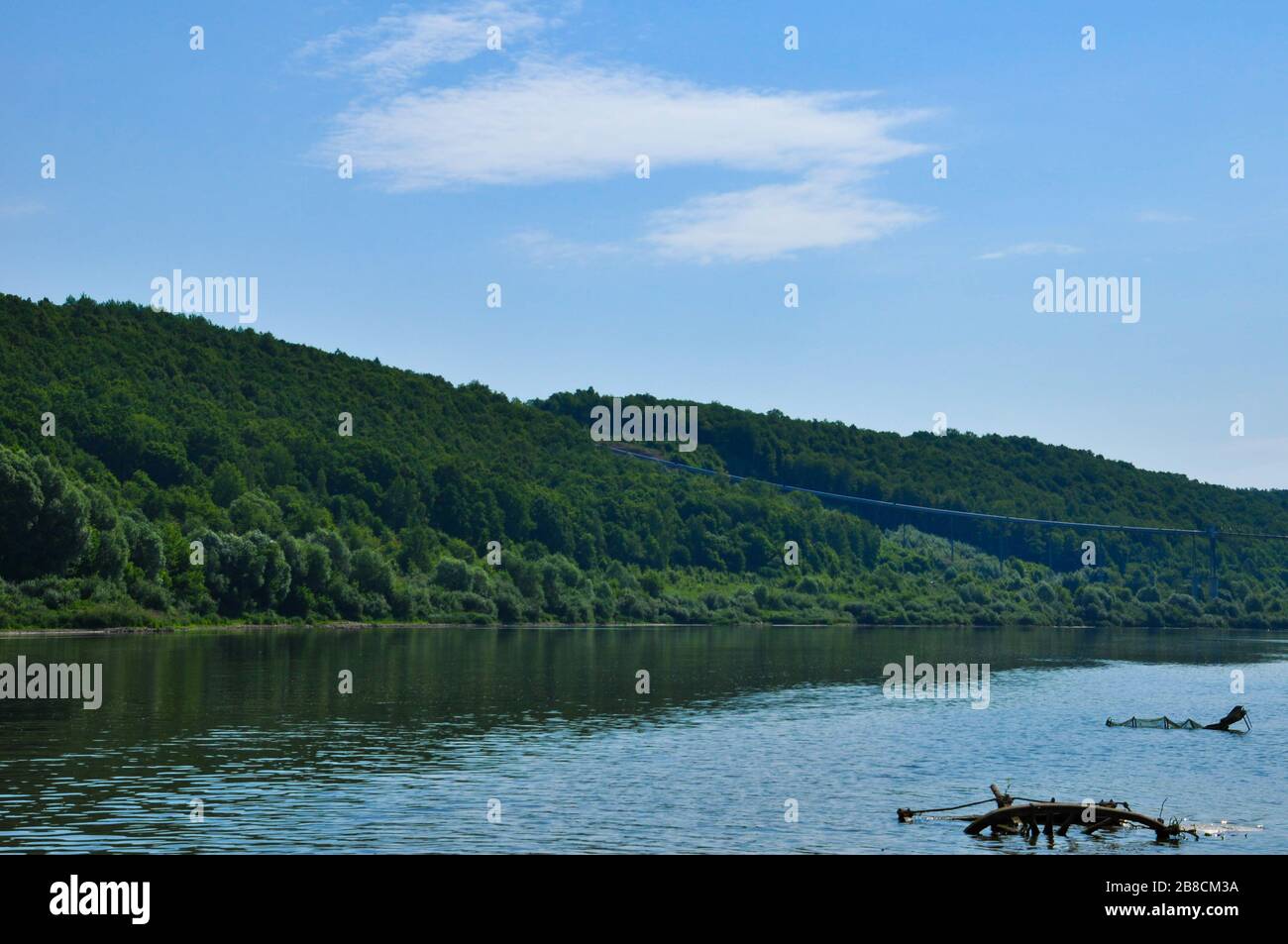 Riverscape on a summer day with Oka river, forest growing on a river bank and cloudy sky. Stock Photo