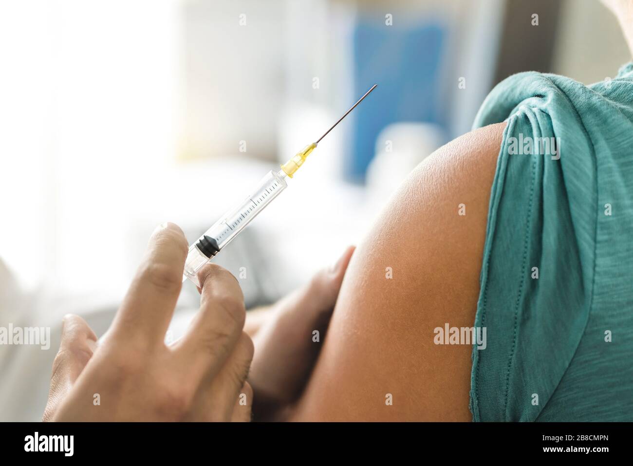 Vaccine or flu shot in injection needle. Doctor working with patient's arm. Physician or nurse giving vaccination and immunity to virus or influenza. Stock Photo