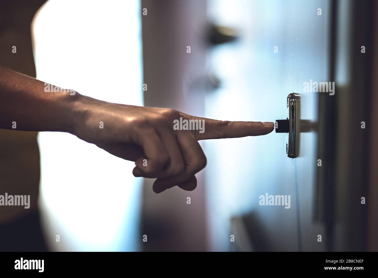 Finger ringing doorbell. Hand pushing door bell. Friend visiting or