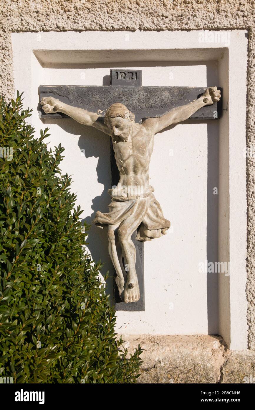 Crucifix (Jesus on the cross) on the wall of Maria Himmelfahrt (Maria am Berg) catholic parish church in Hallstatt, Austria Stock Photo