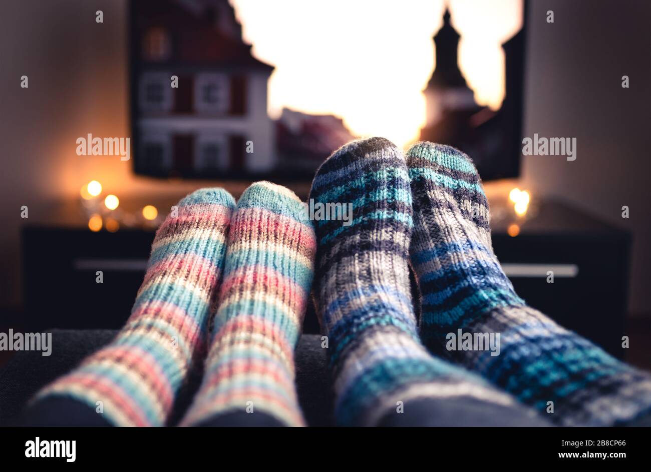 Cozy woolen socks. Couple watching tv in winter. Man and woman using online  streaming service for movies and series. Relaxing quality time on sofa  Stock Photo - Alamy