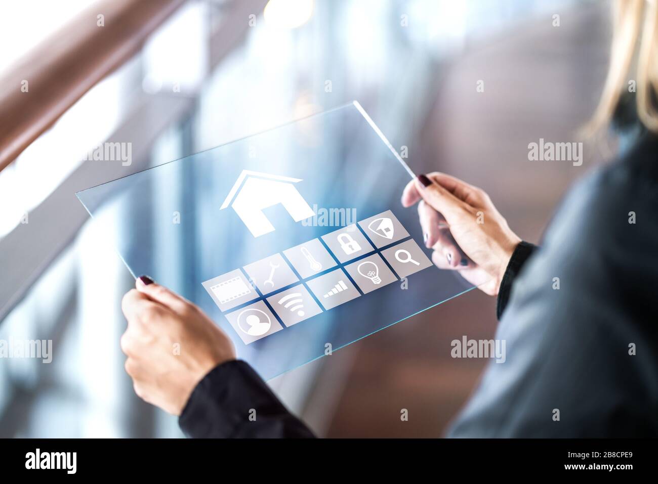 Futuristic smart home control inferface in transparent tablet. Person using digital automated system. Mobile glass device in modern house. Stock Photo