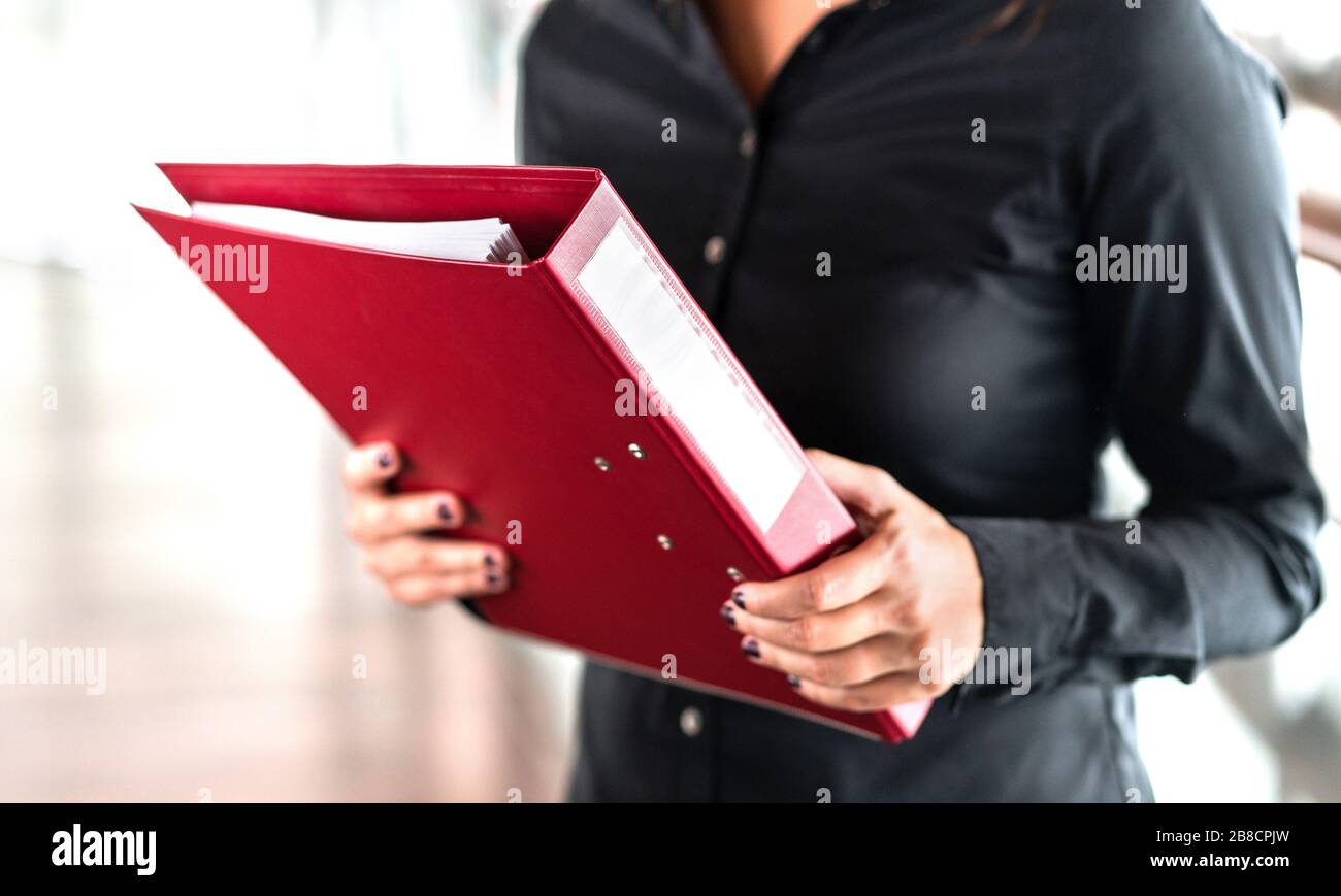 Professional business woman holding folder full of paper documents. Lawyer, legal adviser, office assistant or company manager with binder. Stock Photo