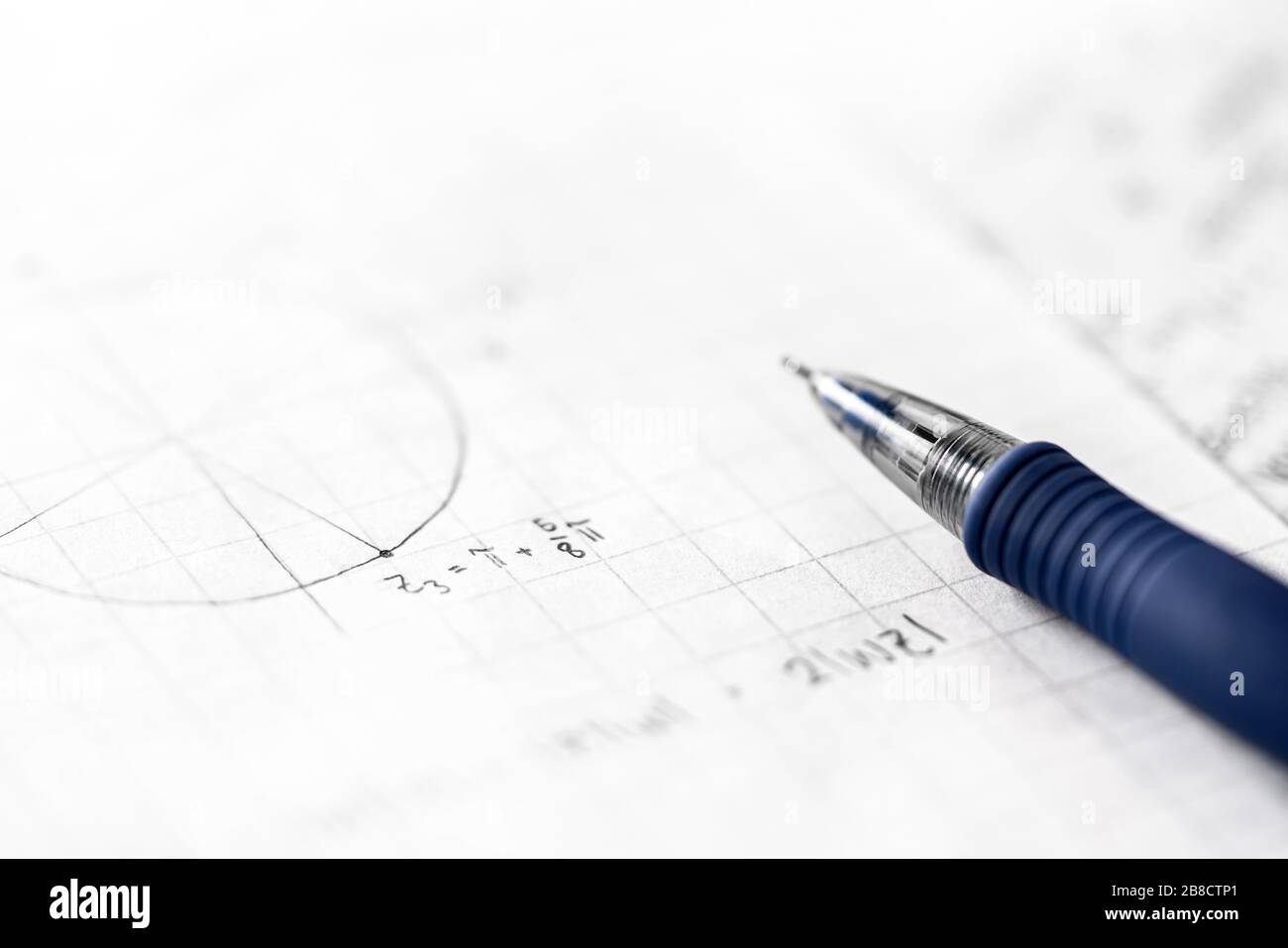 Studying mathematics and science concept. Notes in math class. Geometry, numbers, equation or formula on paper with pen. Homework, exam, assignment. Stock Photo