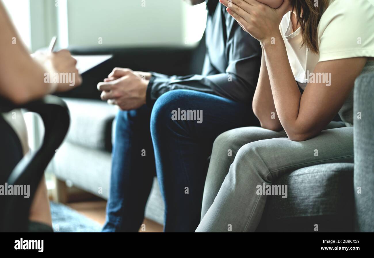 Hopeless and upset couple in therapy. Counseling or meeting with marriage counselor or adoption psychologist. Argument and dispute about divorce. Stock Photo