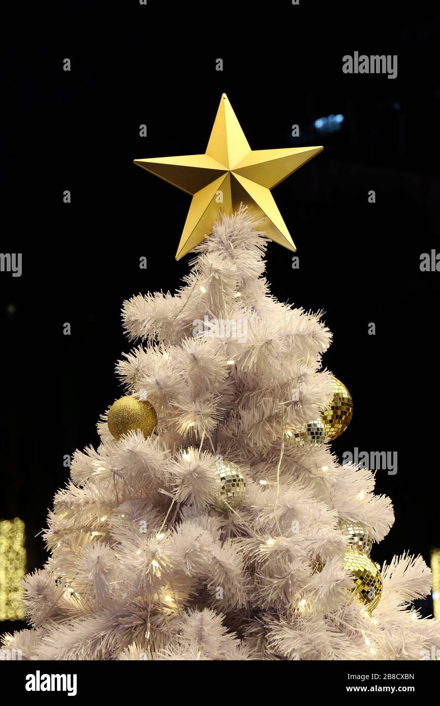 Golden Star and ball decoration on white Christmas tree background night (selective focus) Stock Photo