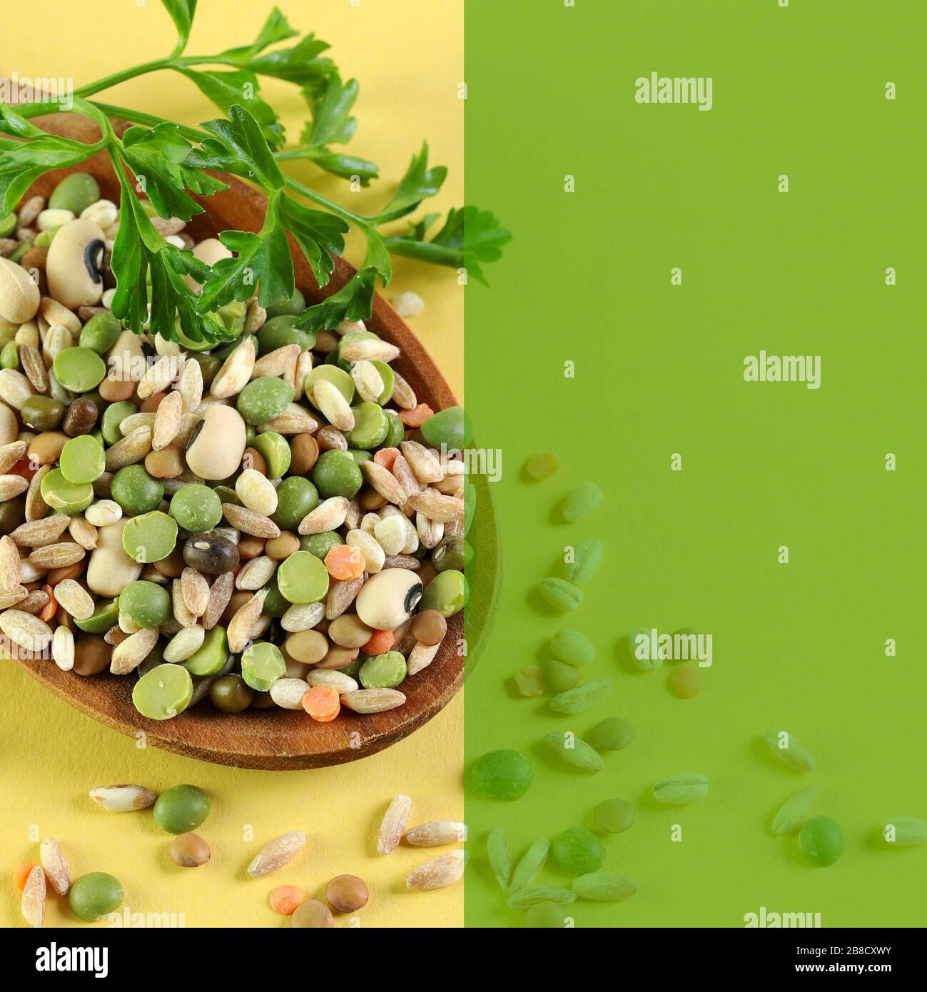 Mix of dried legumes in a wooden spoon. Top view. Semi-trasnparent color copy space. Stock Photo