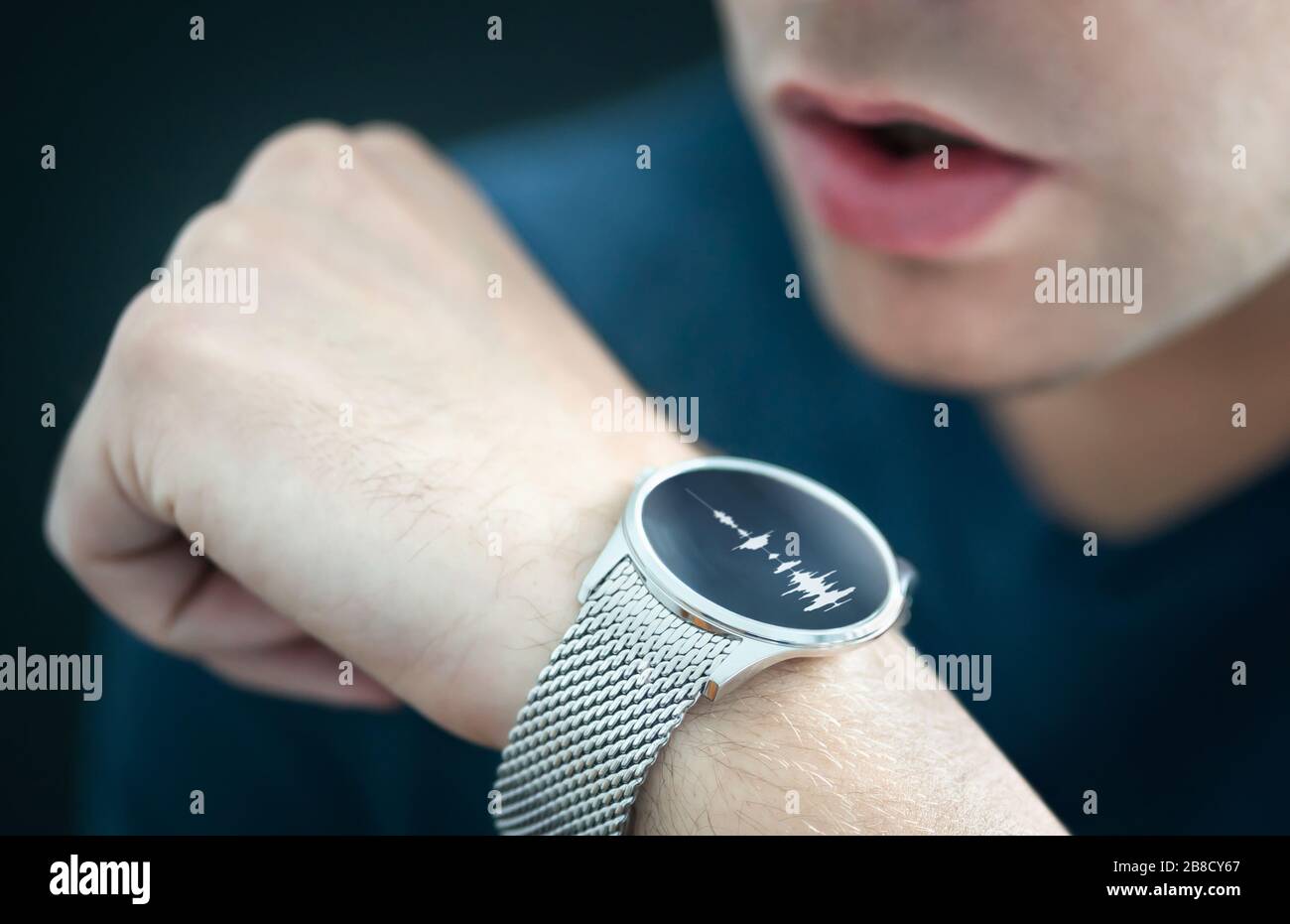 Voice recording or speech recognition technology in smart watch. Man talking to smartwatch mic and recorder. Personal assistant app to give command. Stock Photo