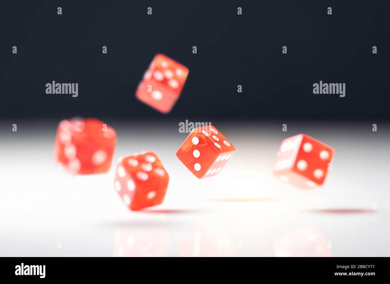 Roll the dice. Risk, luck, gambling, betting or addiction concept. Throwing five red casino and poker dice on table. Stock Photo