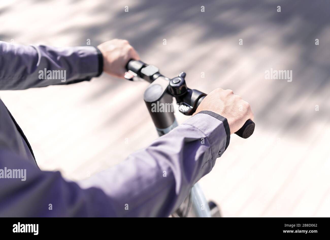 Man driving electric kick scooter fast in city street. High speed e rent vehicle. Transportation safety in traffic concept. Millennial business person. Stock Photo