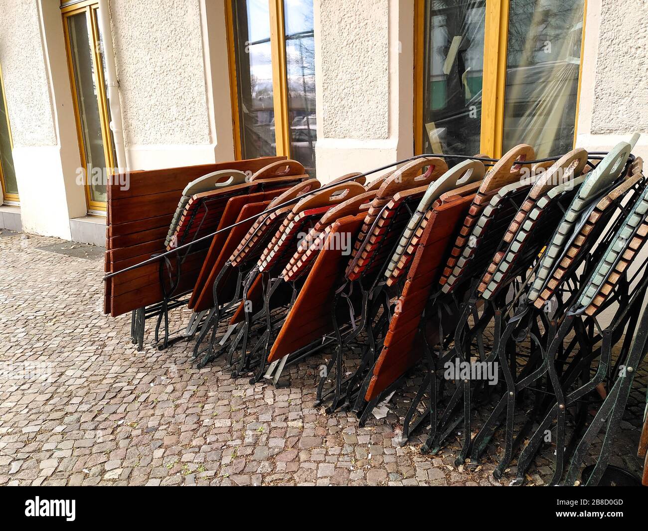 Folded up garden chairs and tables from a restaurant in the hip Friedrichshain neighborhood of Berlin during coronavirus shutdown in Germany. Stock Photo