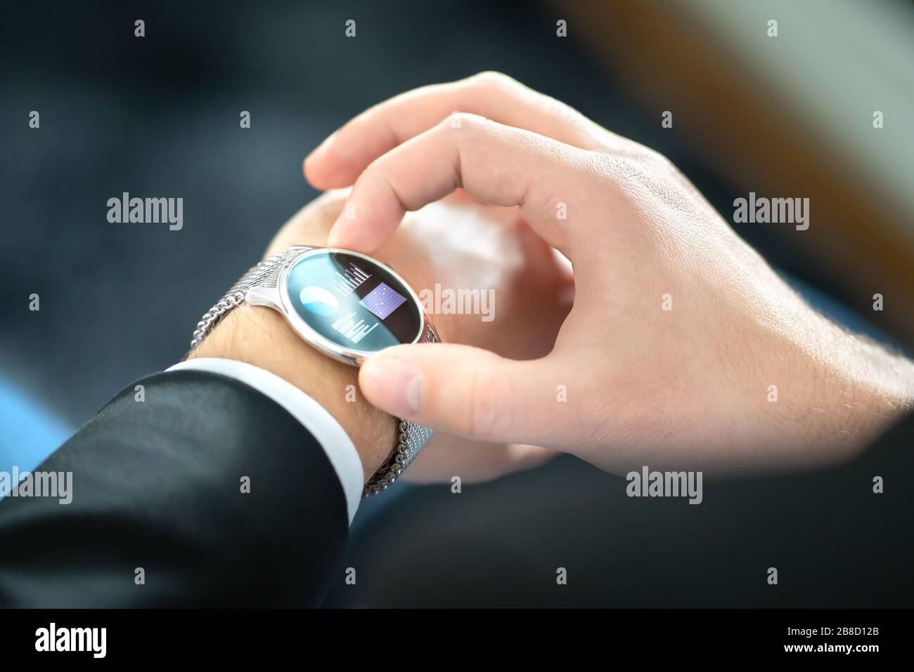 Smart watch with touch screen. Business man using wearable device with mobile technology. Smartwatch with finance report or banking app. Stock Photo