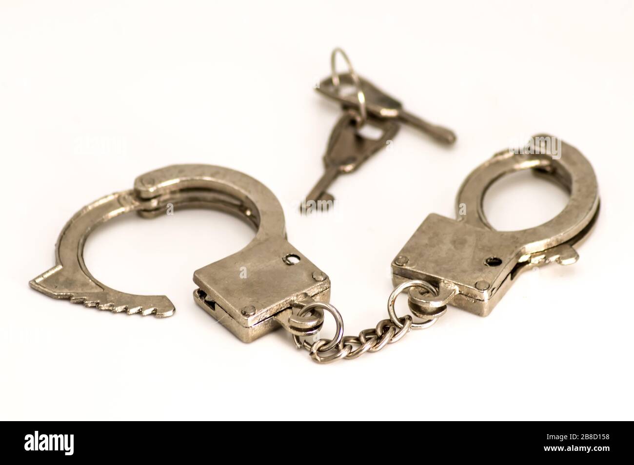 Pair of handcuffs close up front view on a white background Stock Photo