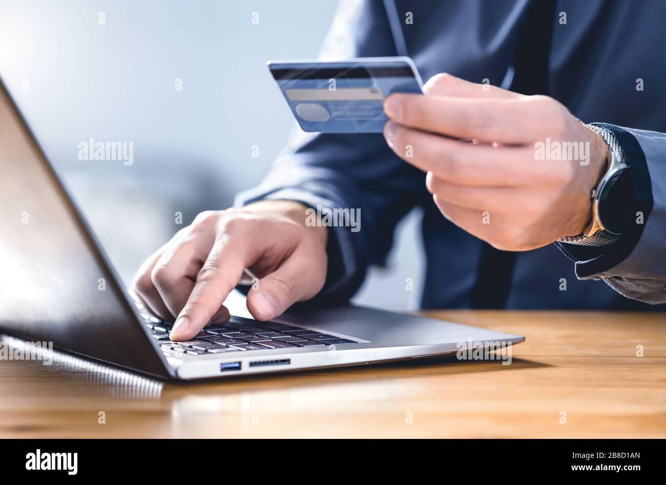 Safe online payment and electronic money transfer security. Pay with digital technology. Man using credit card and laptop to login to internet bank. Stock Photo