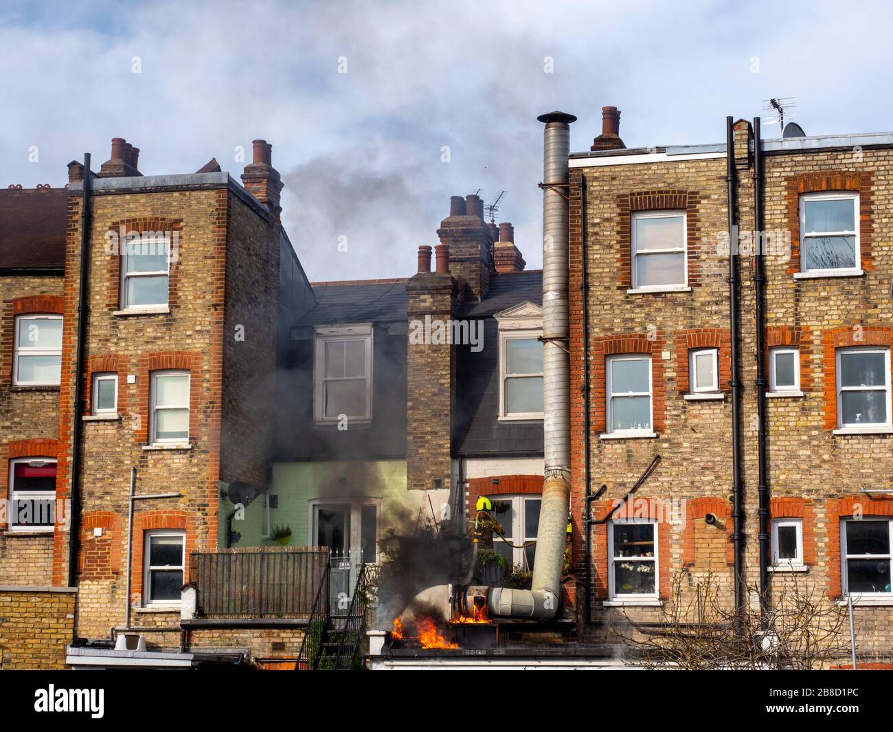 Firefighters tackle a blaze outside a burger shop in north London. Stock Photo