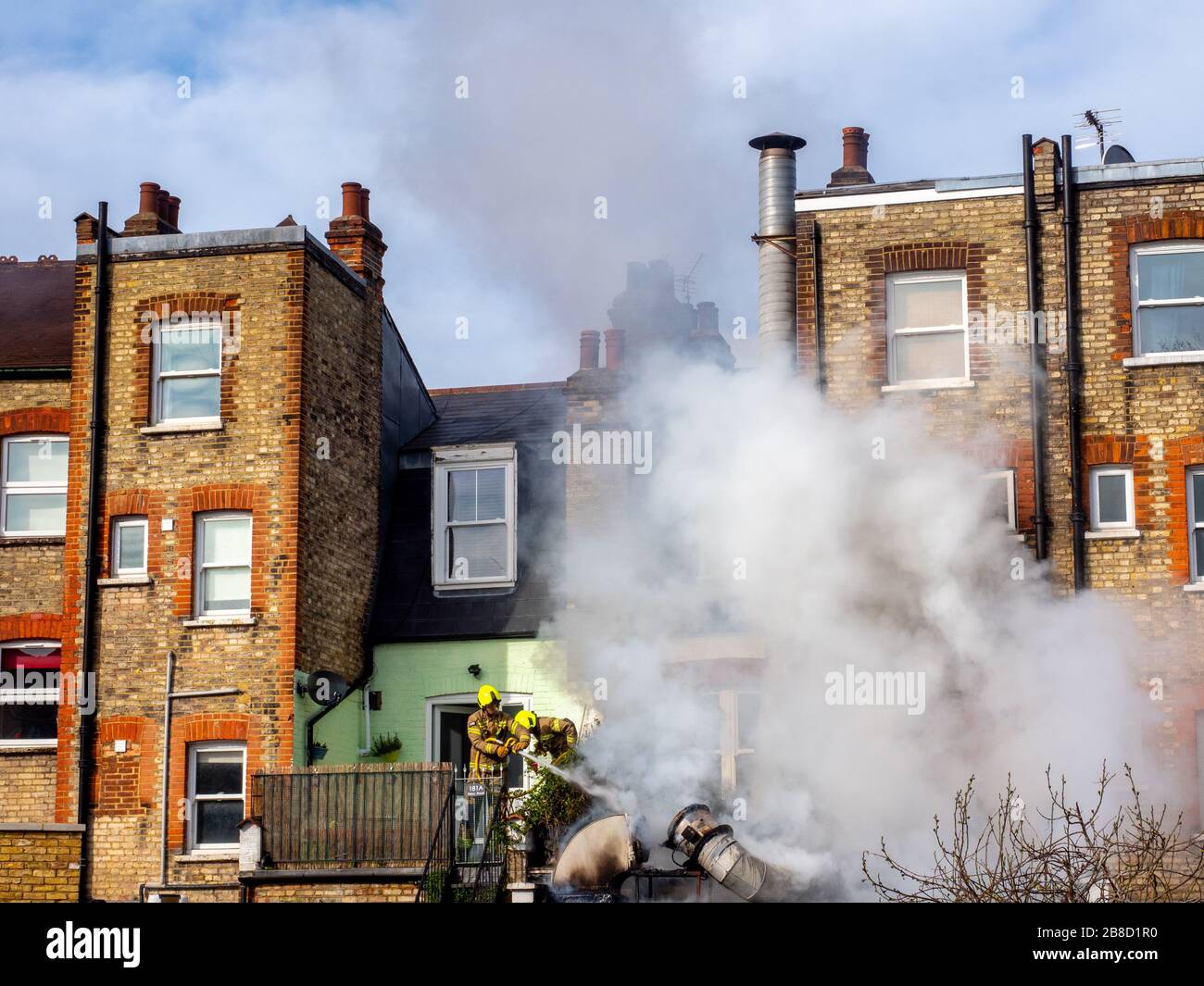 Firefighters tackle a blaze outside a burger shop in north London. Stock Photo