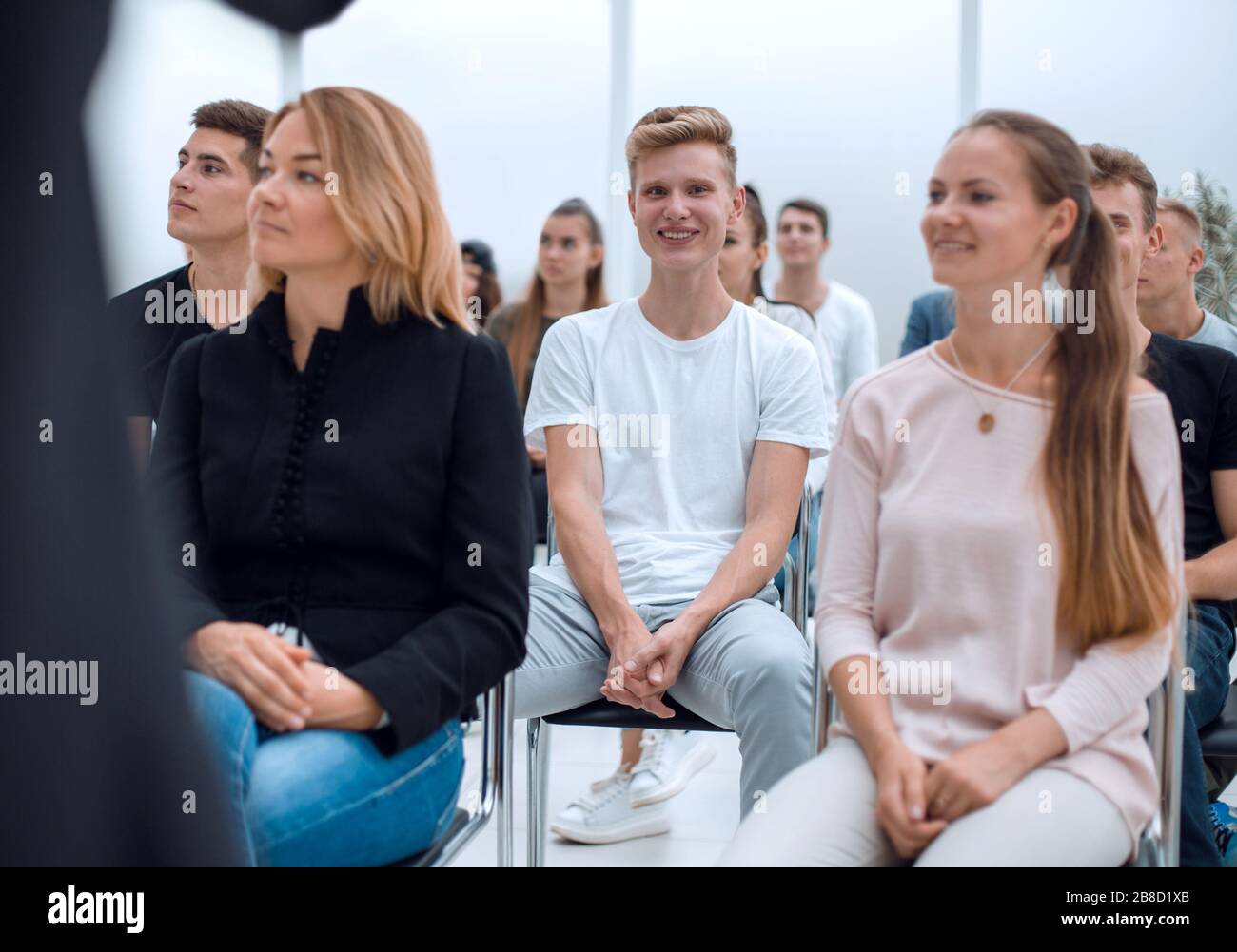 group of diverse young people sitting in a conference room Stock Photo ...
