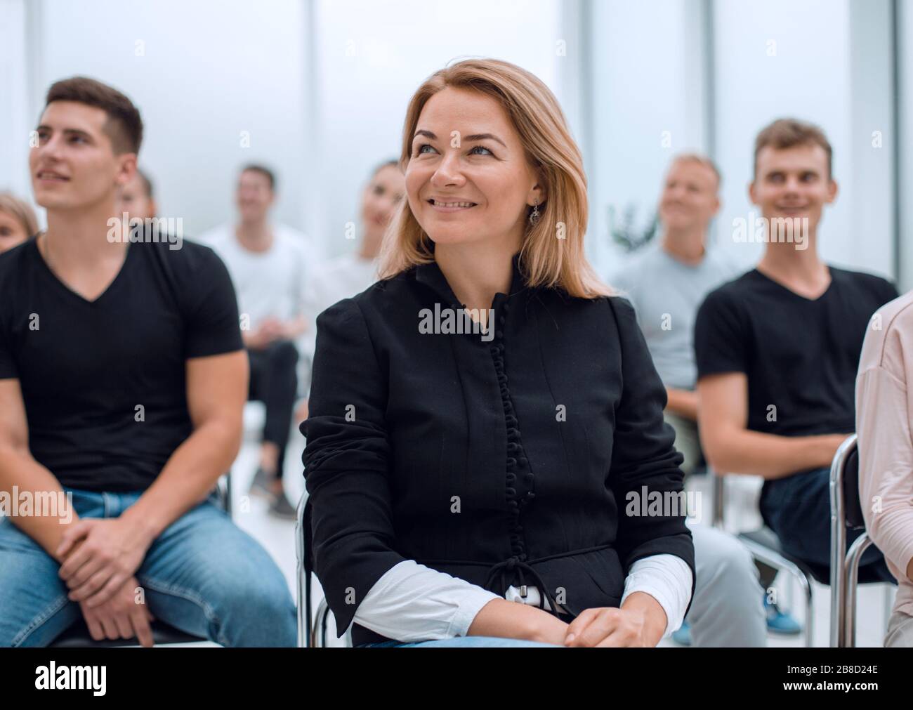 group of diverse young people sitting in a conference room Stock Photo ...