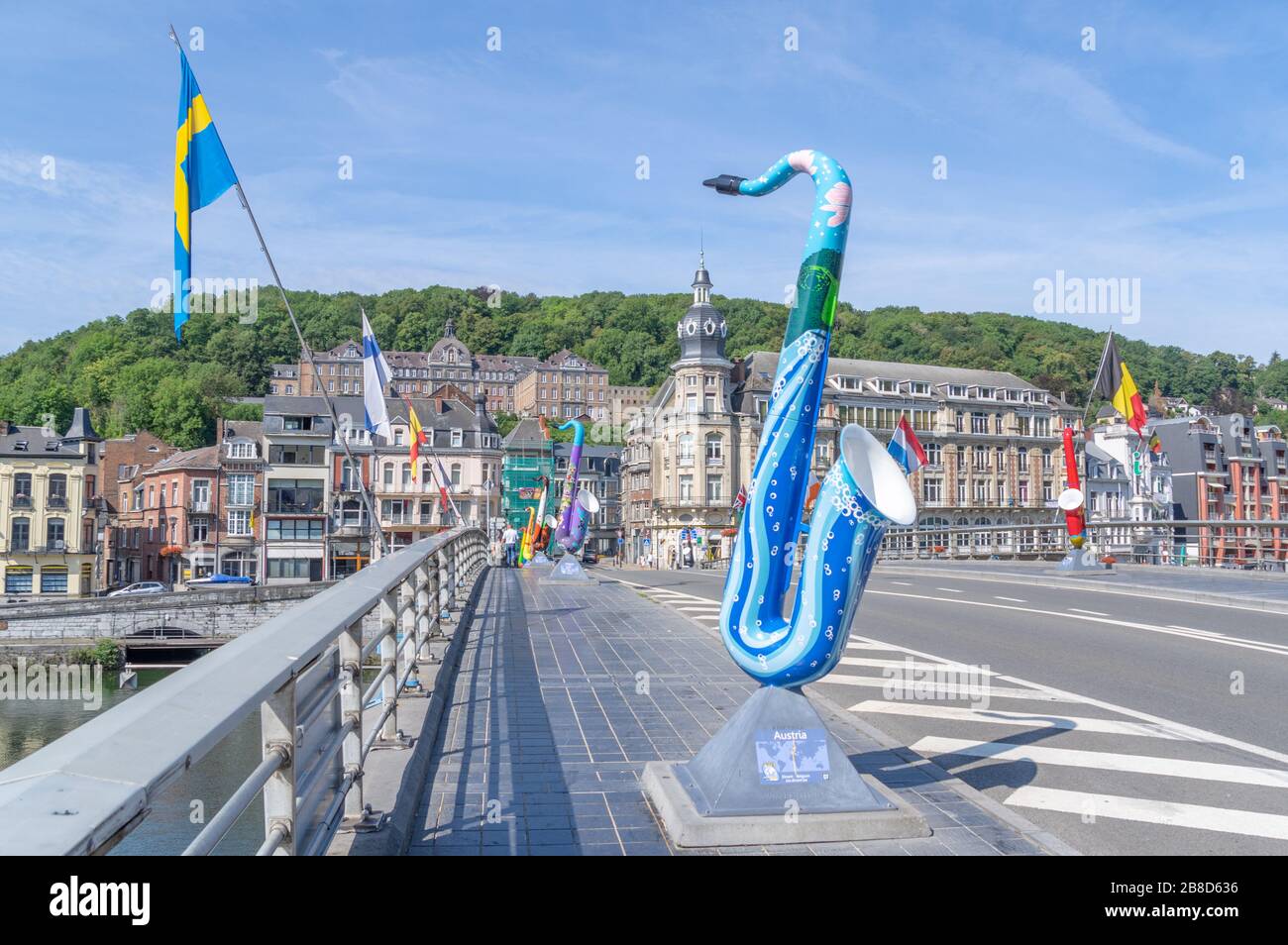Bridge across Meuse river in Dinant, Belgium. The bridge is decorated with sculptures of saxophones, because the inventor Adolphe Sax was from Dinant. Stock Photo