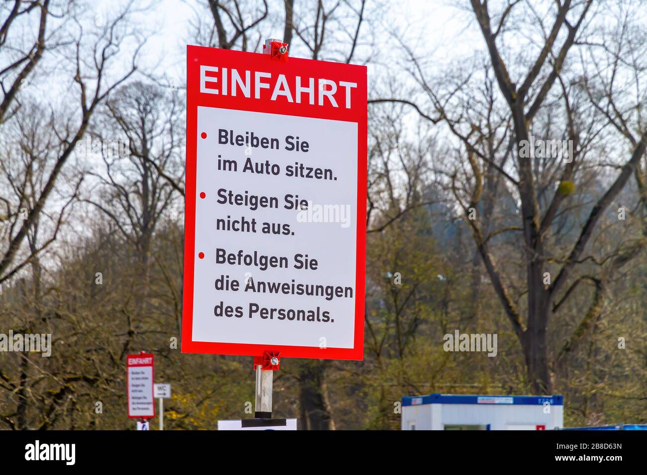 German sign with instructions on a coronavirus test station, Germany Nürtingen ( German Text: Please sit down in the car, don´t get out, follow the in Stock Photo