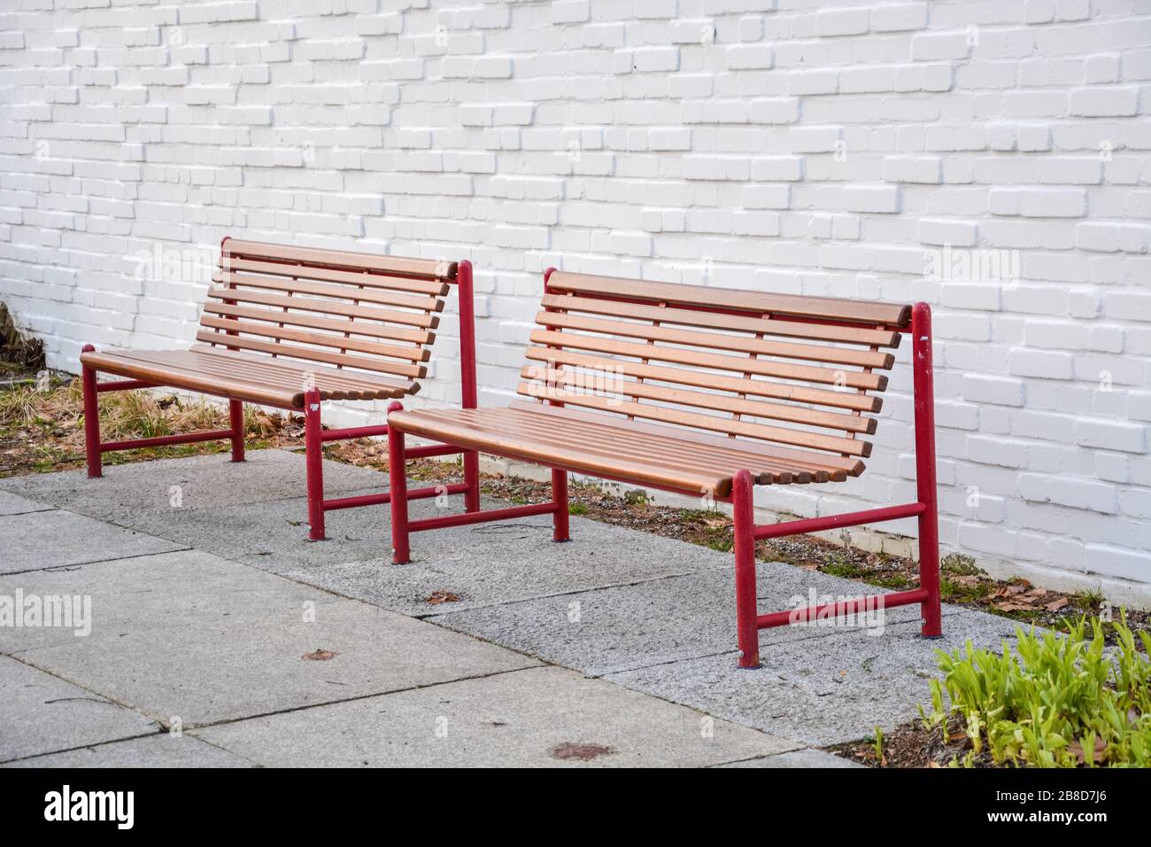 Two benches infront of a white wall from the side Stock Photo - Alamy