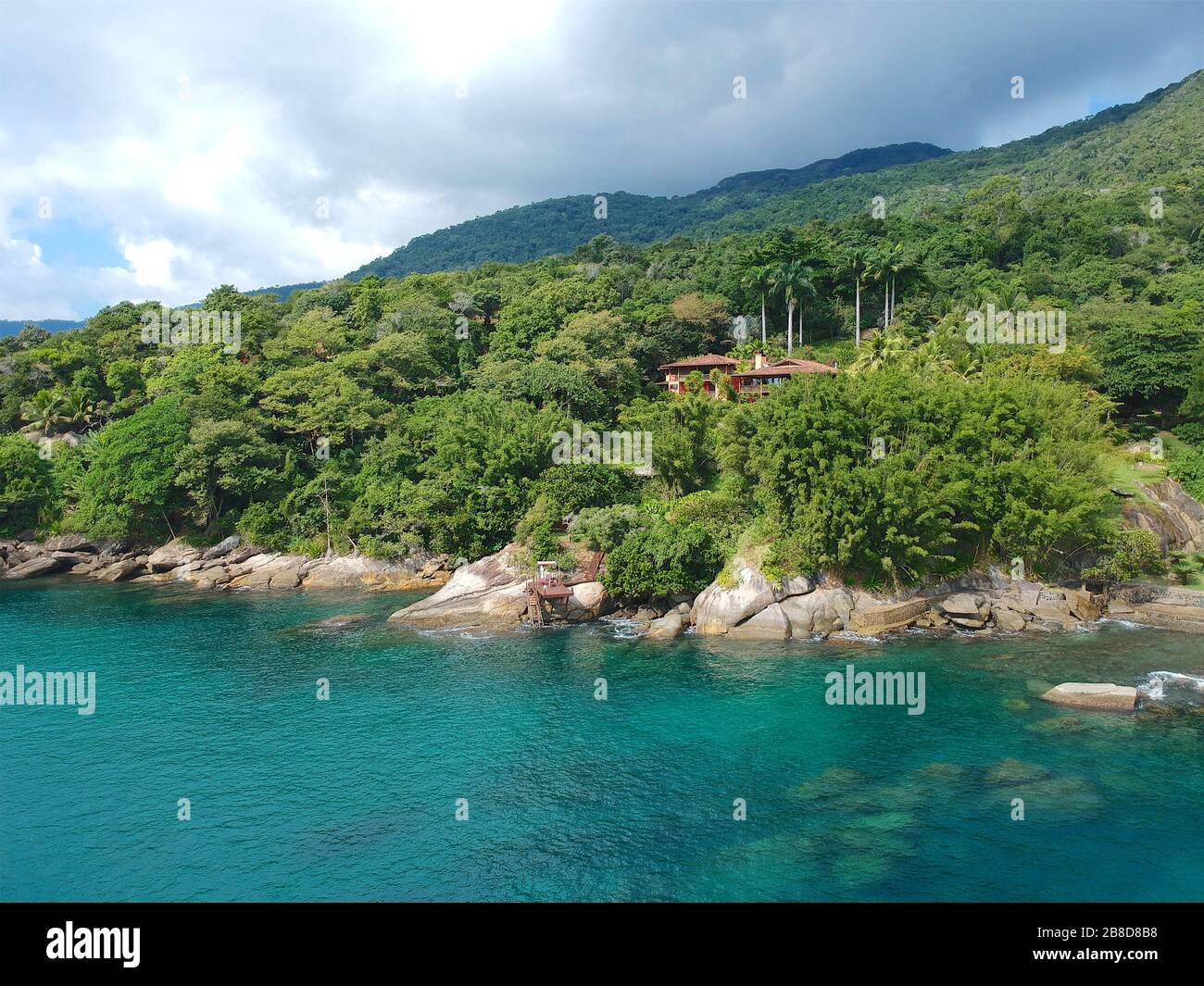 Aerial view of luxury house in tropical forest surrounded by trees and ...