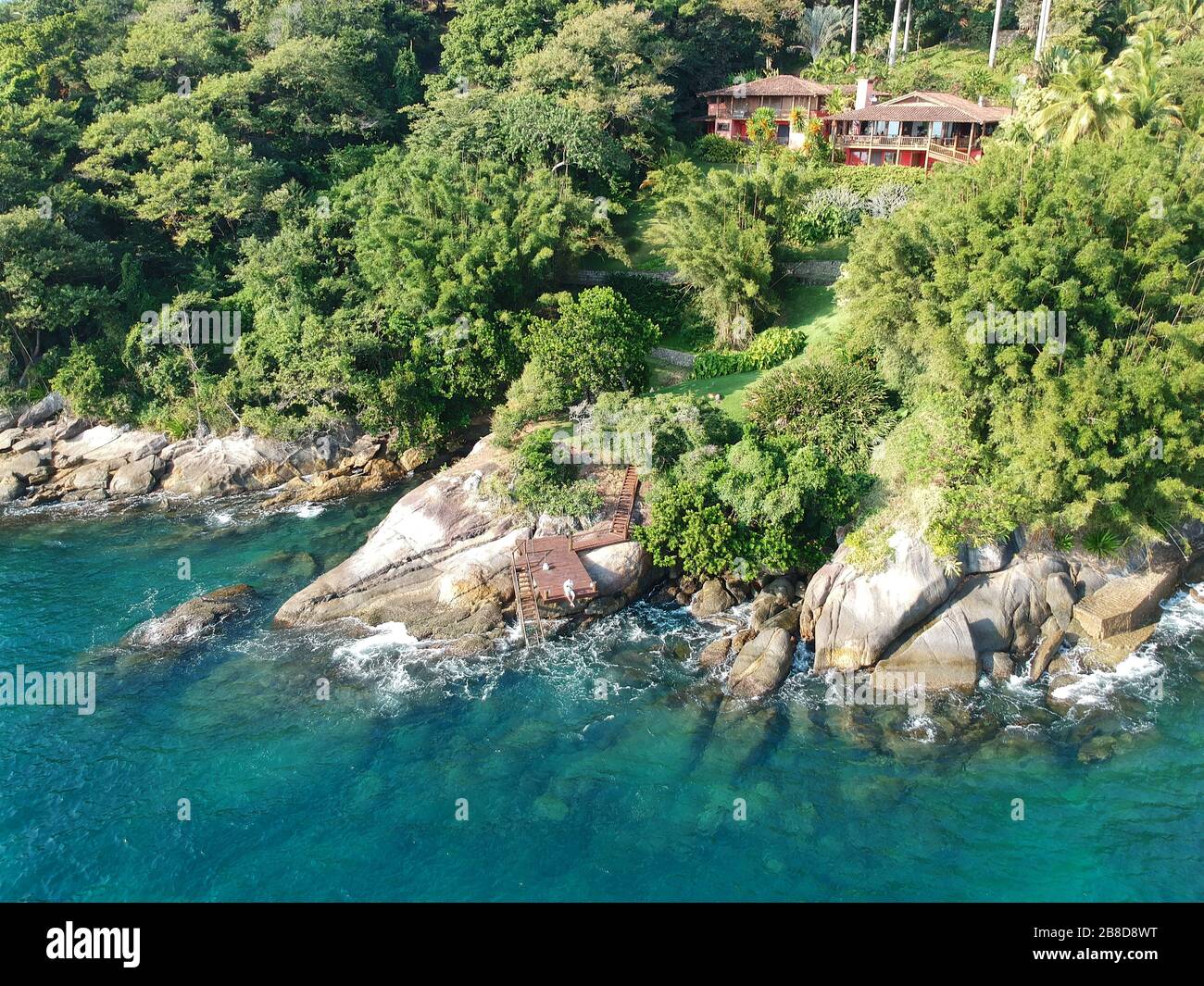 Aerial view of luxury house in tropical forest surrounded by trees and ...