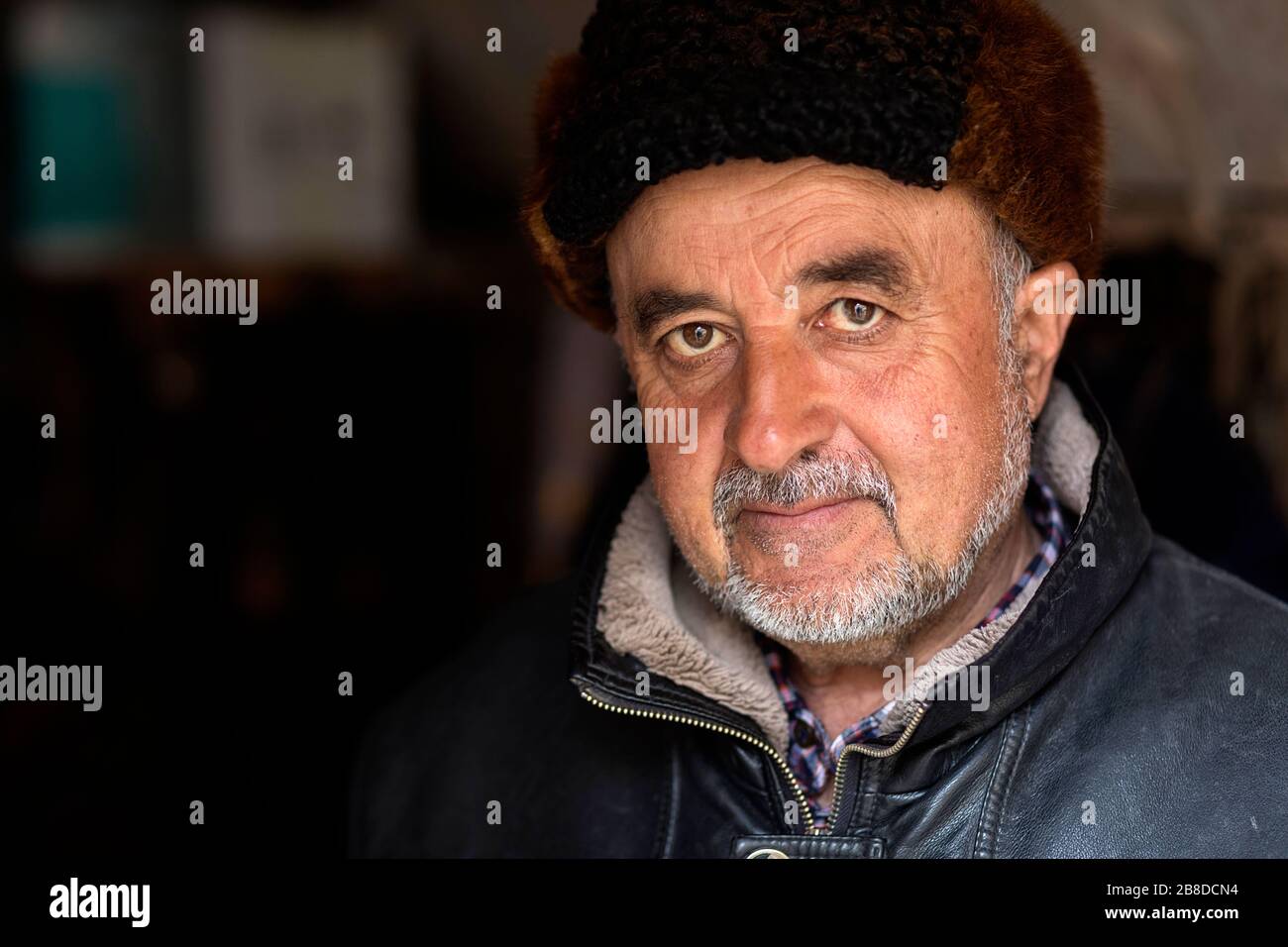 Uzbek man wearing a fur hat and traditional clothes, Uzbekistan, Bukhara Stock Photo